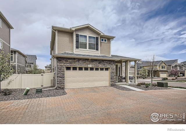3506 Valleywood Ct, Johnstown, CO 80534 - view of front facade featuring fence, a residential view, an attached garage, decorative driveway, and stone siding