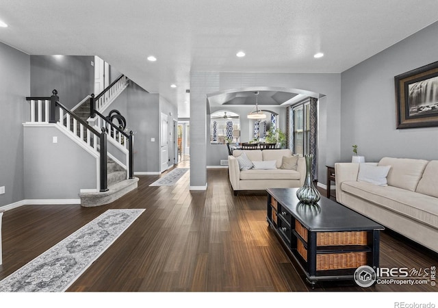 338 Mt Wilson St, Brighton, CO 80601 - living area with arched walkways, wood finished floors, recessed lighting, and stairway