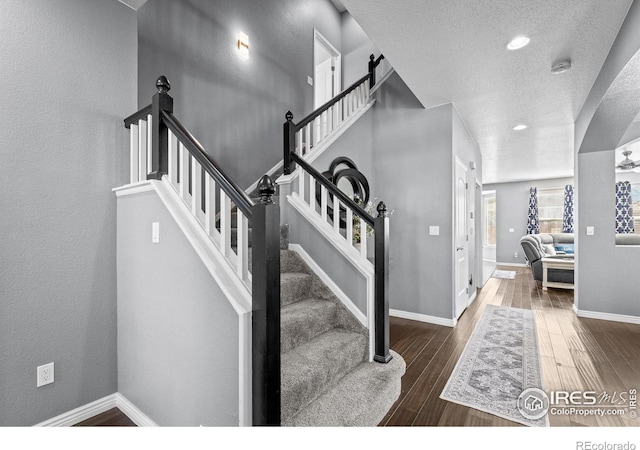 338 Mt Wilson St, Brighton, CO 80601 - staircase featuring wood finished floors, a textured ceiling, and recessed lighting