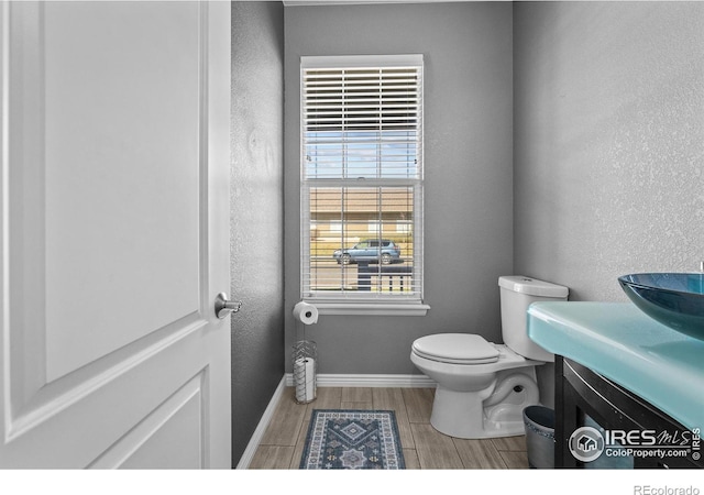 338 Mt Wilson St, Brighton, CO 80601 - half bath with wood finished floors, vanity, and a textured wall
