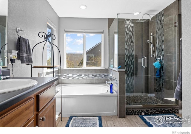 338 Mt Wilson St, Brighton, CO 80601 - full bathroom with a bath, a stall shower, vanity, a textured wall, and recessed lighting