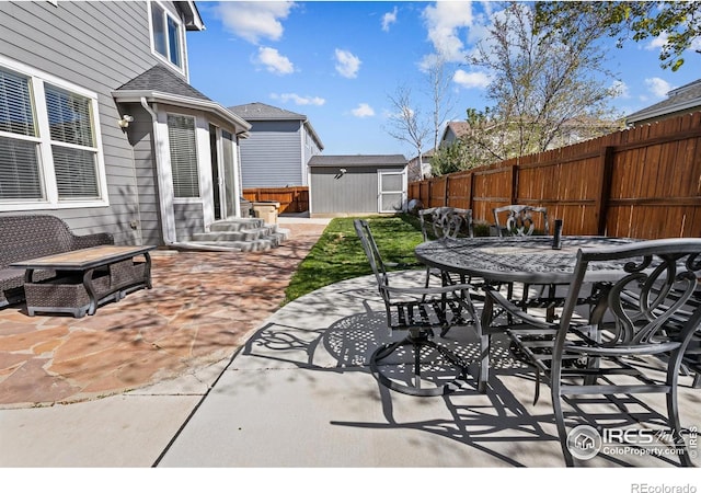 338 Mt Wilson St, Brighton, CO 80601 - fenced backyard with outdoor dining area, a storage unit, and a patio