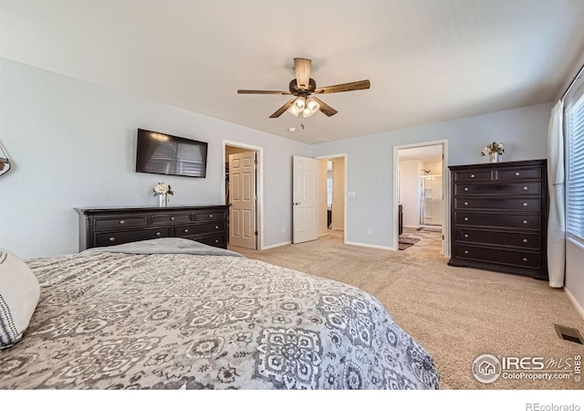 carpeted bedroom featuring ceiling fan, baseboards, ensuite bathroom, and visible vents
