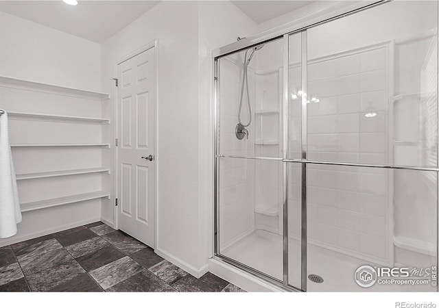 bathroom featuring recessed lighting, baseboards, and a stall shower