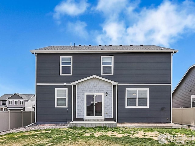 rear view of house with a yard and a fenced backyard
