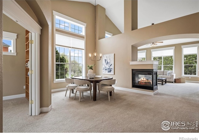 3122 Notabon Ct, Lafayette, CO 80026 - carpeted dining area featuring a multi sided fireplace, a ceiling fan, baseboards, and a wealth of natural light