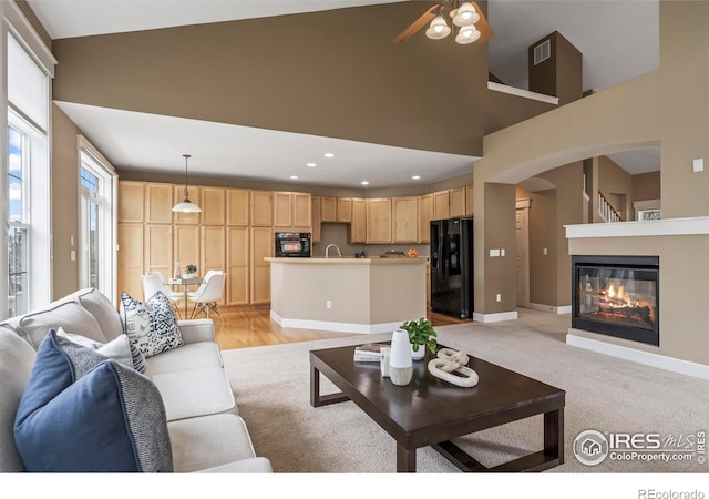 3122 Notabon Ct, Lafayette, CO 80026 - living area with a ceiling fan, arched walkways, high vaulted ceiling, baseboards, and a glass covered fireplace