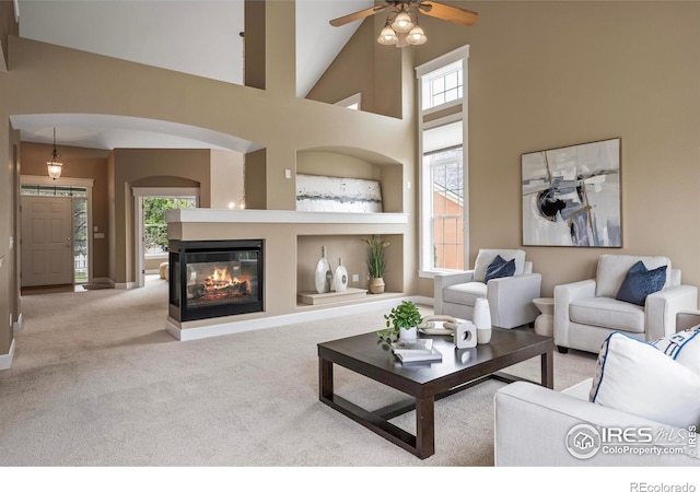 3122 Notabon Ct, Lafayette, CO 80026 - carpeted living area with baseboards, a multi sided fireplace, a ceiling fan, and a wealth of natural light