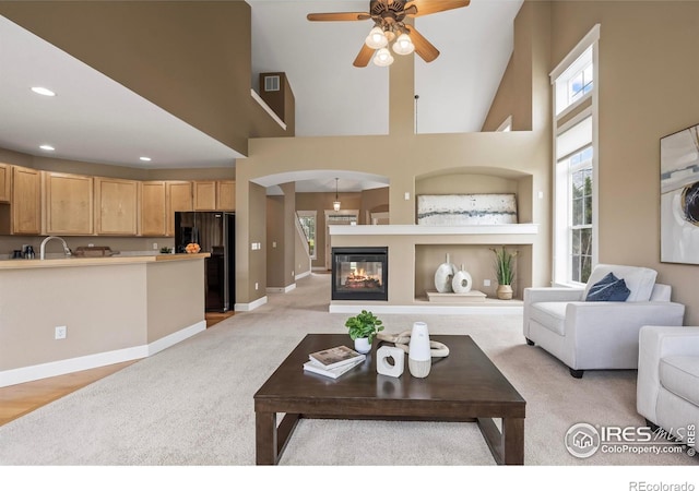 3122 Notabon Ct, Lafayette, CO 80026 - living area featuring ceiling fan, visible vents, light colored carpet, arched walkways, and baseboards