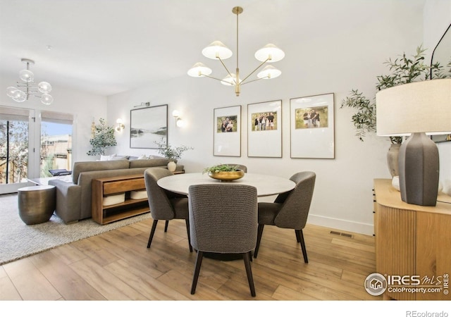 267 Clementina St, Louisville, CO 80027 - dining room featuring light wood finished floors, baseboards, an inviting chandelier, and visible vents