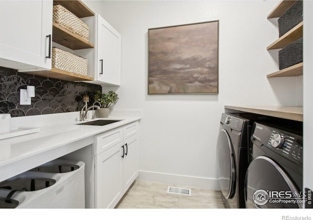 267 Clementina St, Louisville, CO 80027 - clothes washing area with washer and clothes dryer, visible vents, a sink, baseboards, and cabinet space