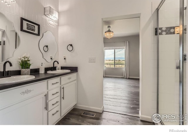 6021 Sandstone Cir, Erie, CO 80516 - bathroom featuring double vanity, baseboards, wood finished floors, and a sink