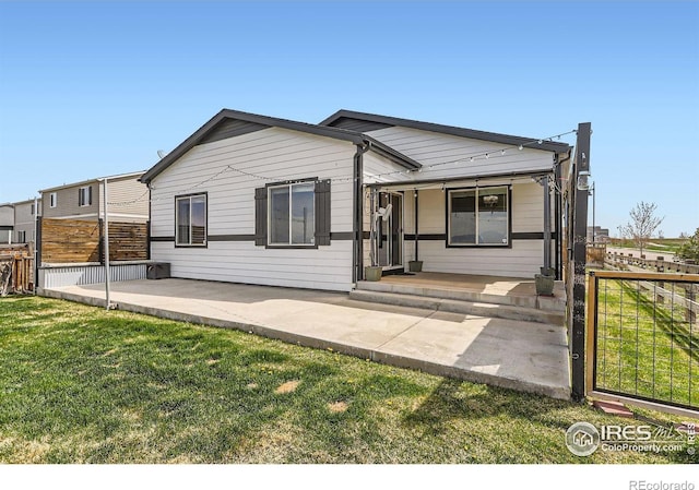 6021 Sandstone Cir, Erie, CO 80516 - rear view of property with covered porch, a lawn, and fence