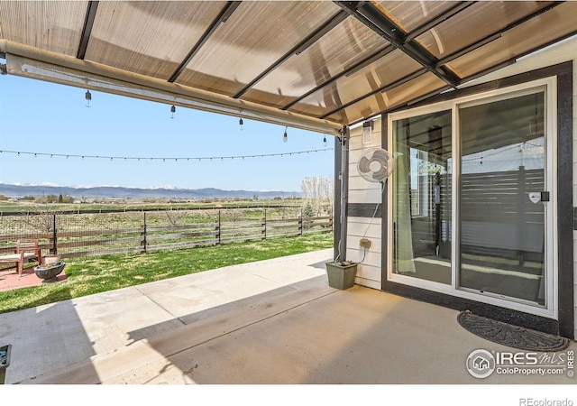 6021 Sandstone Cir, Erie, CO 80516 - view of patio / terrace with a mountain view, fence, and a rural view