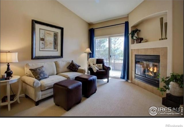 living area with carpet flooring, vaulted ceiling, and a fireplace