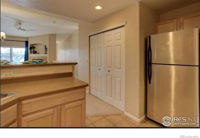 kitchen with light tile patterned floors, light countertops, freestanding refrigerator, light carpet, and recessed lighting
