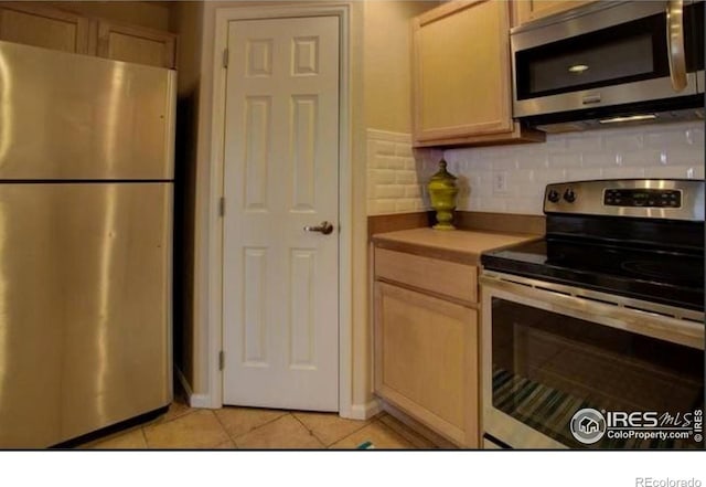 kitchen with light brown cabinets, light countertops, tasteful backsplash, appliances with stainless steel finishes, and light tile patterned floors