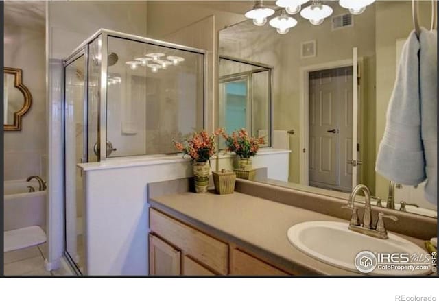 full bath with visible vents, tile patterned flooring, a shower stall, vanity, and a chandelier