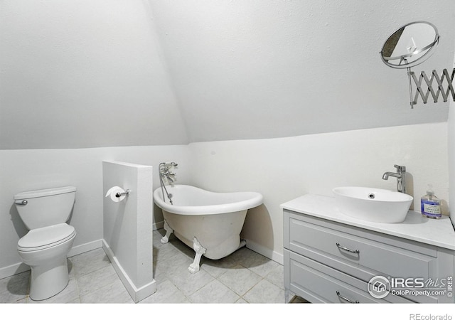 3059 N York St, Denver, CO 80205 - bathroom with vanity, baseboards, toilet, lofted ceiling, and a soaking tub