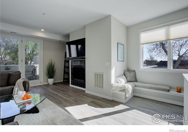 living area featuring baseboards, wood finished floors, visible vents, and recessed lighting