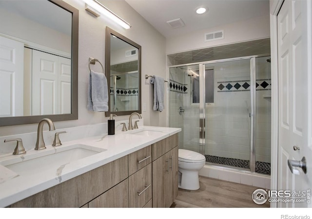 bathroom featuring visible vents, a sink, and a stall shower