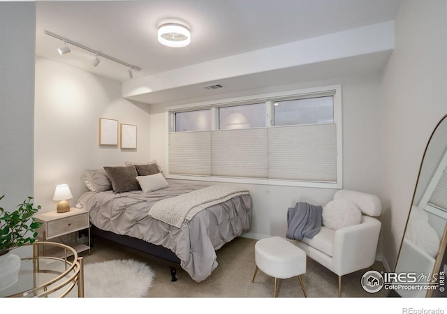 carpeted bedroom featuring track lighting and visible vents
