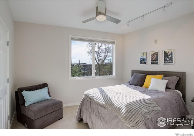 bedroom featuring baseboards, carpet floors, rail lighting, and ceiling fan