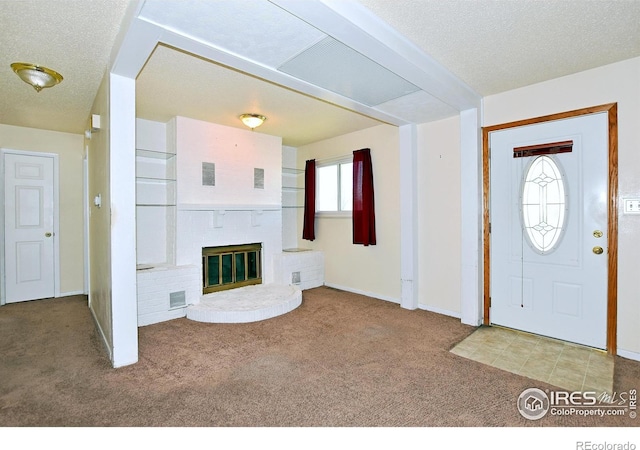 foyer entrance featuring baseboards, a brick fireplace, visible vents, and carpet