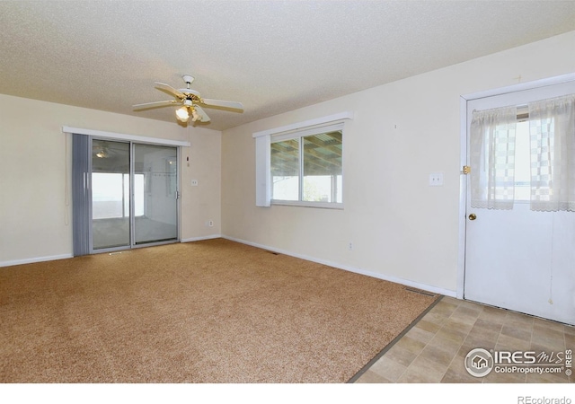 empty room featuring visible vents, light carpet, a ceiling fan, and baseboards