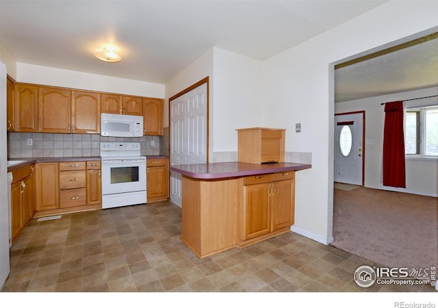 kitchen with a peninsula, light carpet, tasteful backsplash, visible vents, and white appliances