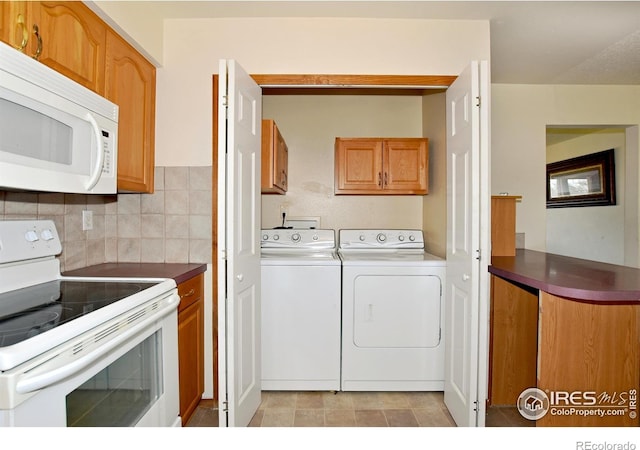 washroom featuring washing machine and dryer and cabinet space