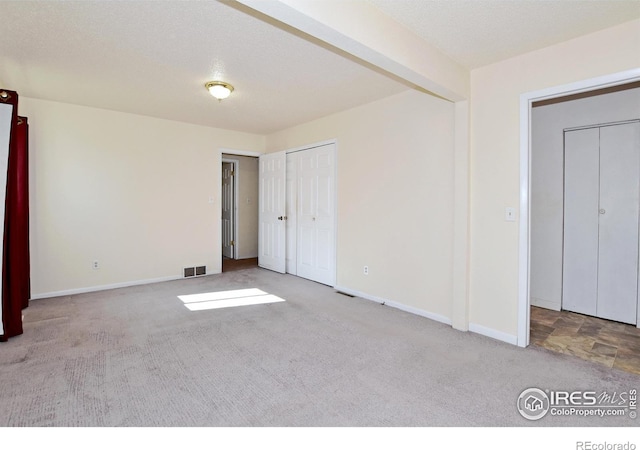 unfurnished bedroom with visible vents, carpet flooring, and baseboards