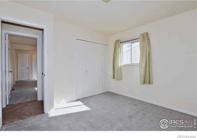 unfurnished bedroom with baseboards, carpet, and a closet