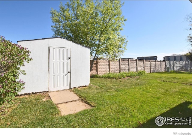 view of yard featuring an outdoor structure, a shed, and fence