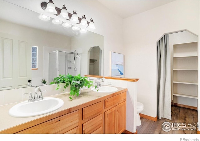 9040 Painted Horse Ln, Wellington, CO 80549 - full bathroom featuring a shower stall, toilet, wood finished floors, and a sink