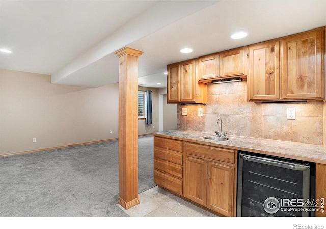 9040 Painted Horse Ln, Wellington, CO 80549 - kitchen featuring wine cooler, a sink, tasteful backsplash, baseboards, and light colored carpet