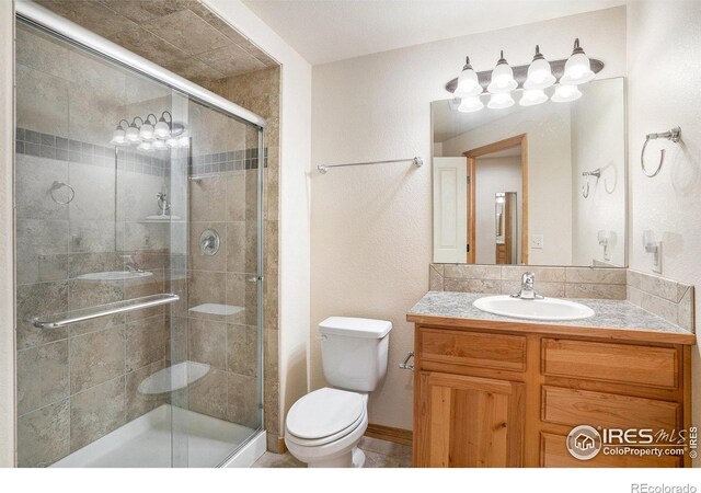 9040 Painted Horse Ln, Wellington, CO 80549 - full bathroom with vanity, a shower stall, and toilet