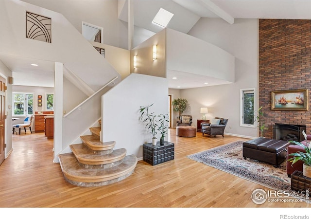 5285 Gallatin Pl, Boulder, CO 80303 - living area featuring high vaulted ceiling, stairs, wood finished floors, a skylight, and beamed ceiling