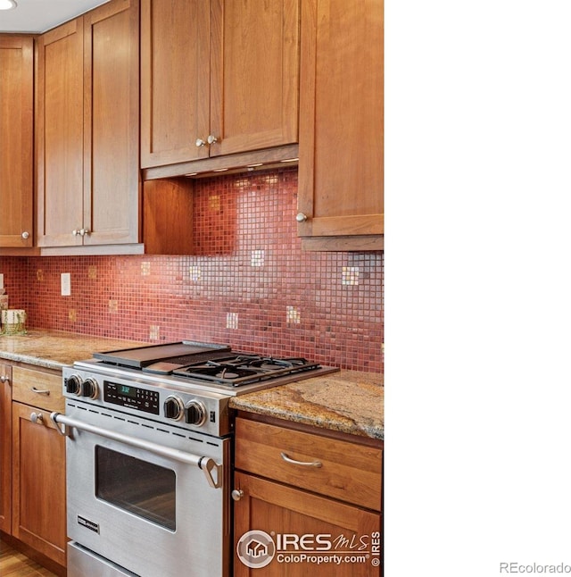 5285 Gallatin Pl, Boulder, CO 80303 - kitchen featuring light stone counters, stainless steel stove, decorative backsplash, and under cabinet range hood