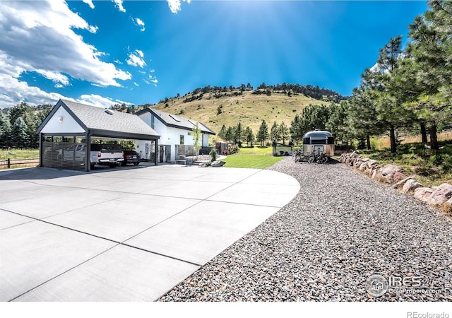 view of patio / terrace with driveway, fence, and a mountain view