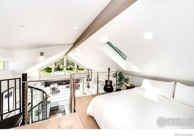bedroom with vaulted ceiling with skylight, wood finished floors, and recessed lighting