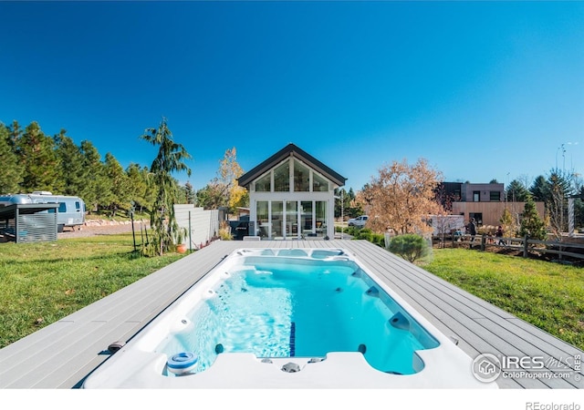 view of swimming pool featuring a lawn, fence, a fenced in pool, and a storage structure