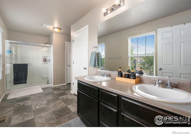 bathroom with visible vents, a sink, baseboards, and a shower stall