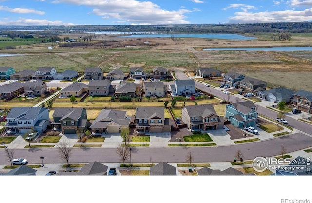 drone / aerial view with a water view and a residential view