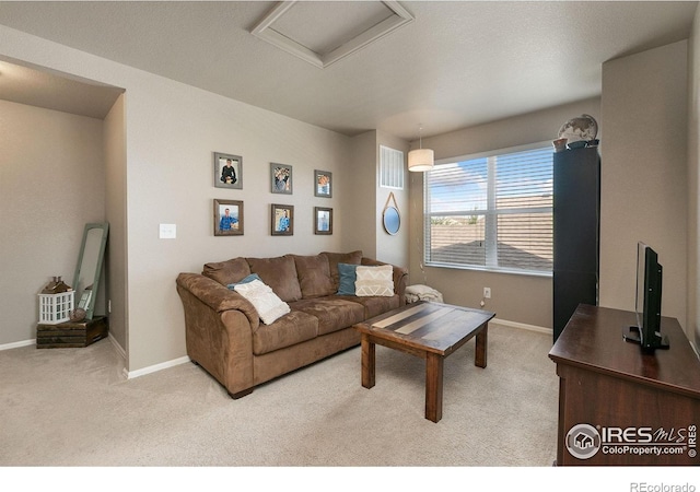 living area with baseboards, attic access, carpet, and visible vents