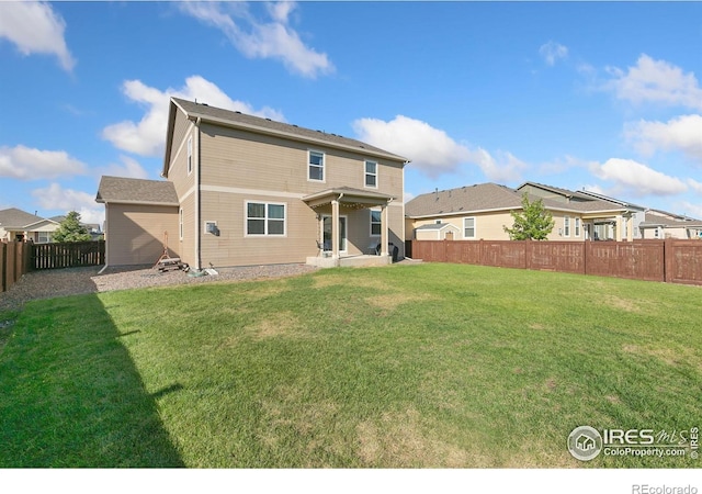 back of property with a fenced backyard and a yard