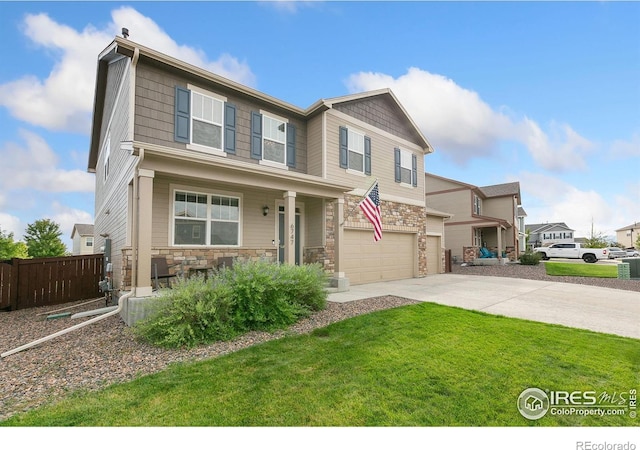 craftsman-style house featuring fence, covered porch, a front yard, concrete driveway, and an attached garage