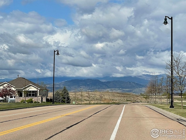view of road with street lighting, curbs, and a mountain view