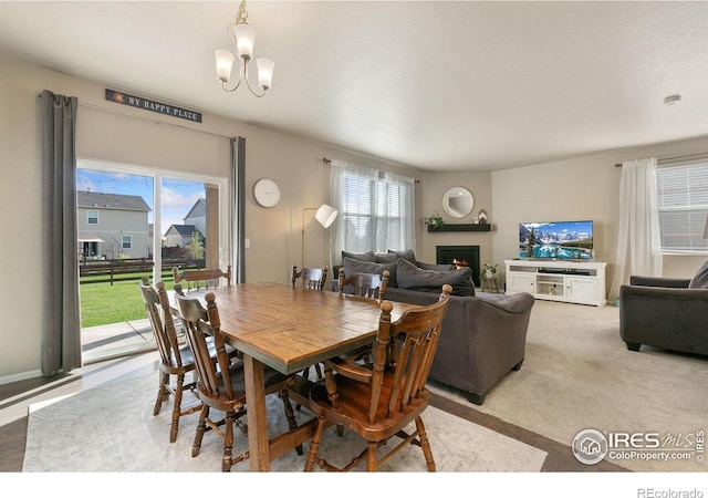 6747 Grainery Rd, Timnath, CO 80547 - dining space featuring a lit fireplace and a chandelier