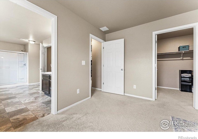 6747 Grainery Rd, Timnath, CO 80547 - unfurnished bedroom with a spacious closet, baseboards, and carpet floors